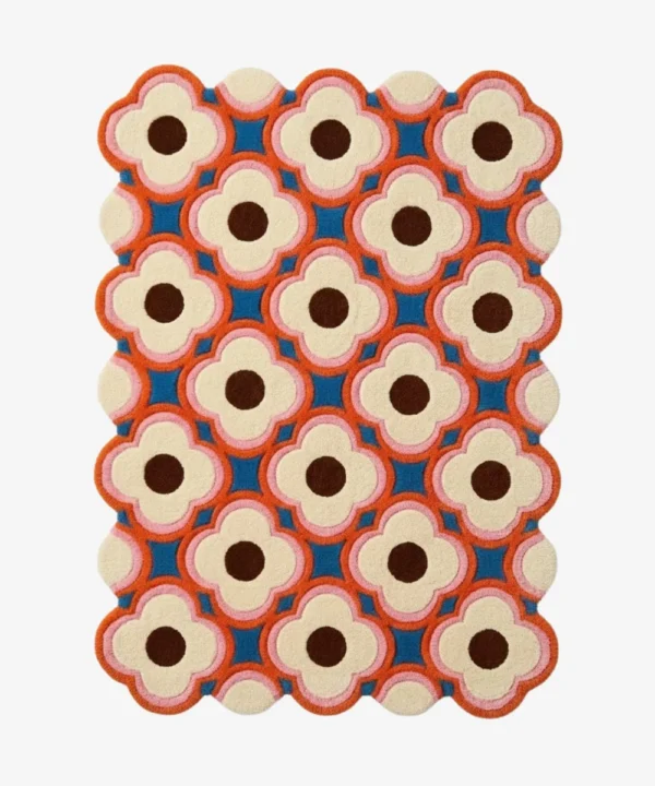Full view of a modern retro style wool rug with scalloped edges showcasing a colorful blush pink and deep blue flower pattern perfect for adding a pop of color.