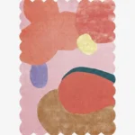 Top-down view of the Rose Riot rug against a white background, featuring large, organic abstract shapes in vibrant shades of coral, peach, yellow, periwinkle, teal, and warm brown on a soft pink background, framed by a continuous pink scalloped border.