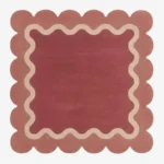 Top down view of the Rose Whisper Square rug featuring a deep rose central field framed by a wavy cream line and a soft pink scalloped border.