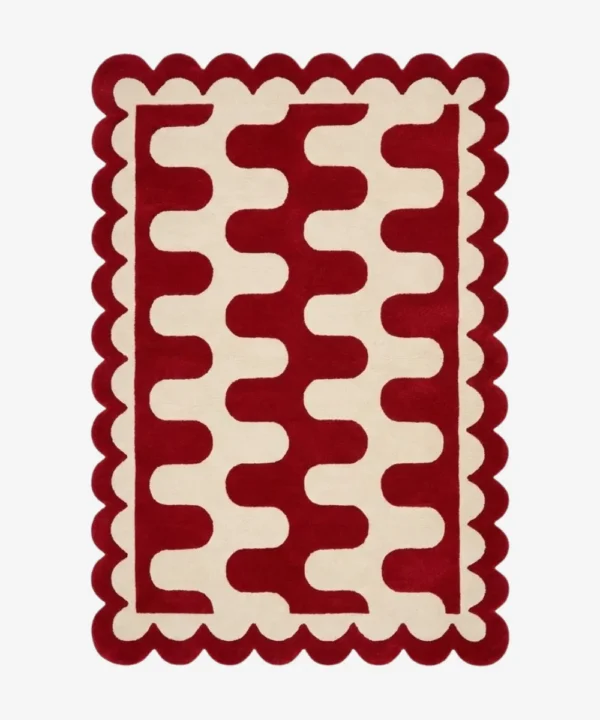 Top down view of the Ruby Weave rug featuring a deep red wool background with a bold cream wavy geometric pattern and custom scalloped edges.
