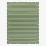 Top down view of the Sage Rhythm rug featuring a solid sage green color with horizontal carved textures and decorative scalloped edges.