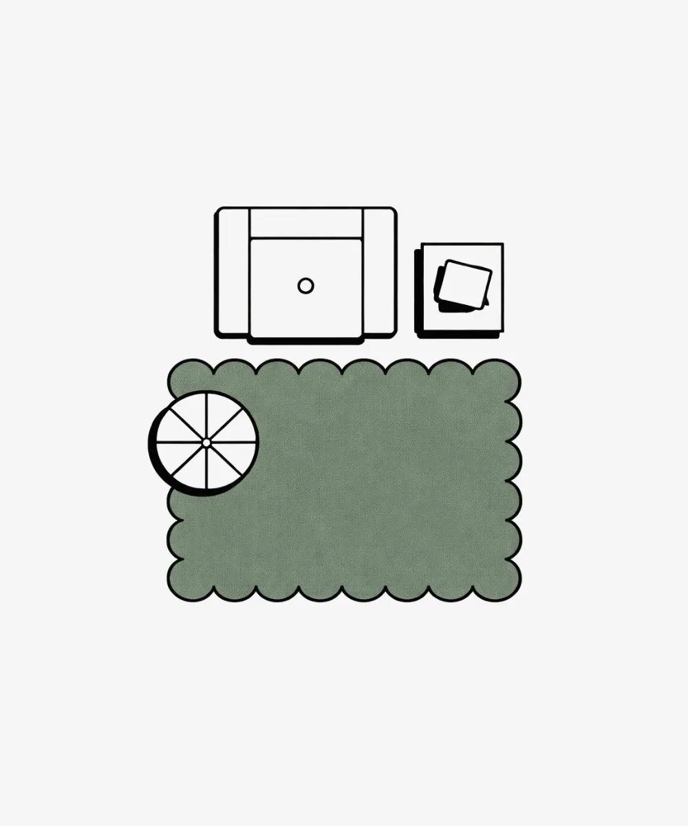 Layout illustration for the ScallopedRugs 5x8ft collection showing a small green scalloped rug placed in front of a reading chair and side table to define a cozy accent corner.