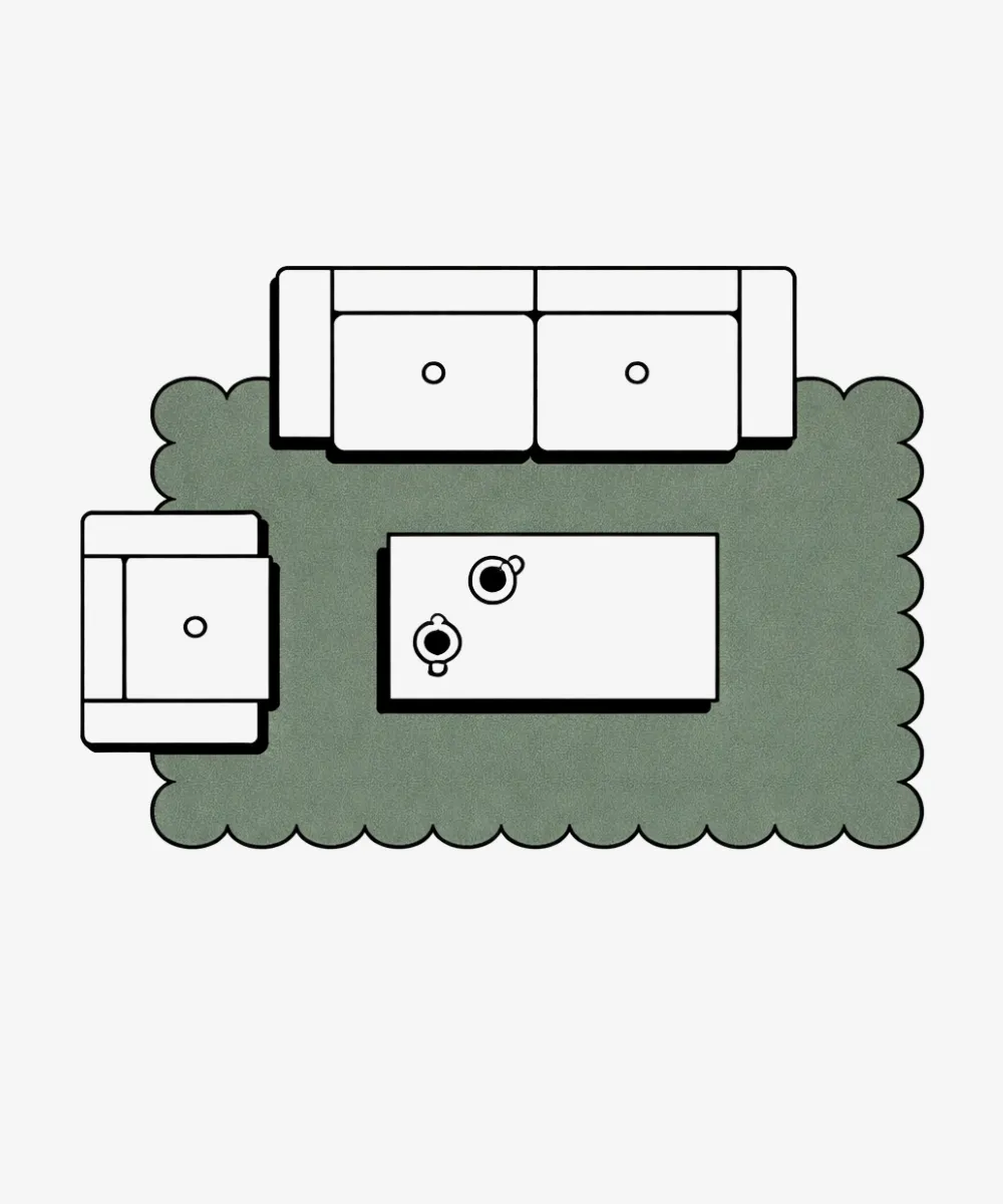 Top-down furniture placement guide for a 9x12ft scalloped rug. The illustration shows a standard sofa and armchair arranged partially on the rug to anchor a medium-sized living space.