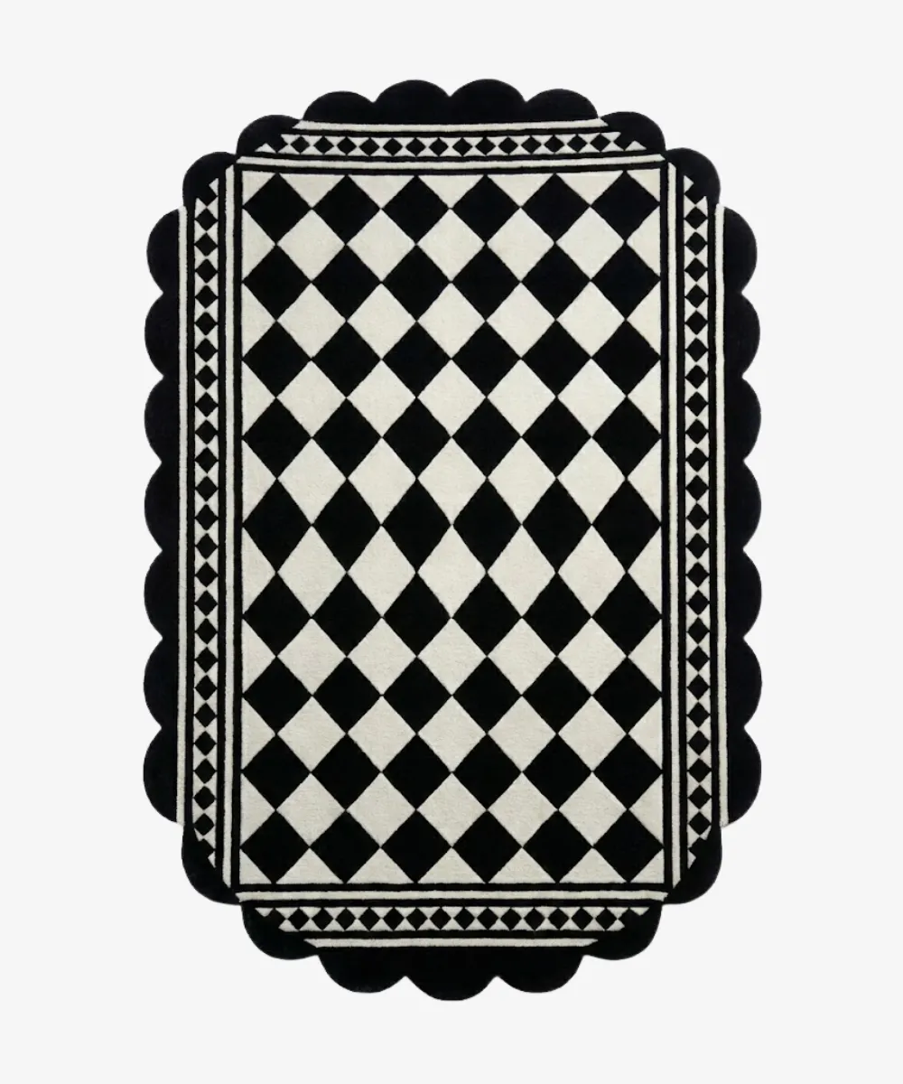 Top down view of a hand tufted wool rug for the ScallopedRugs Black Rugs category featuring a classic black and white harlequin diamond design with intricate geometric borders and custom scalloped edges.
