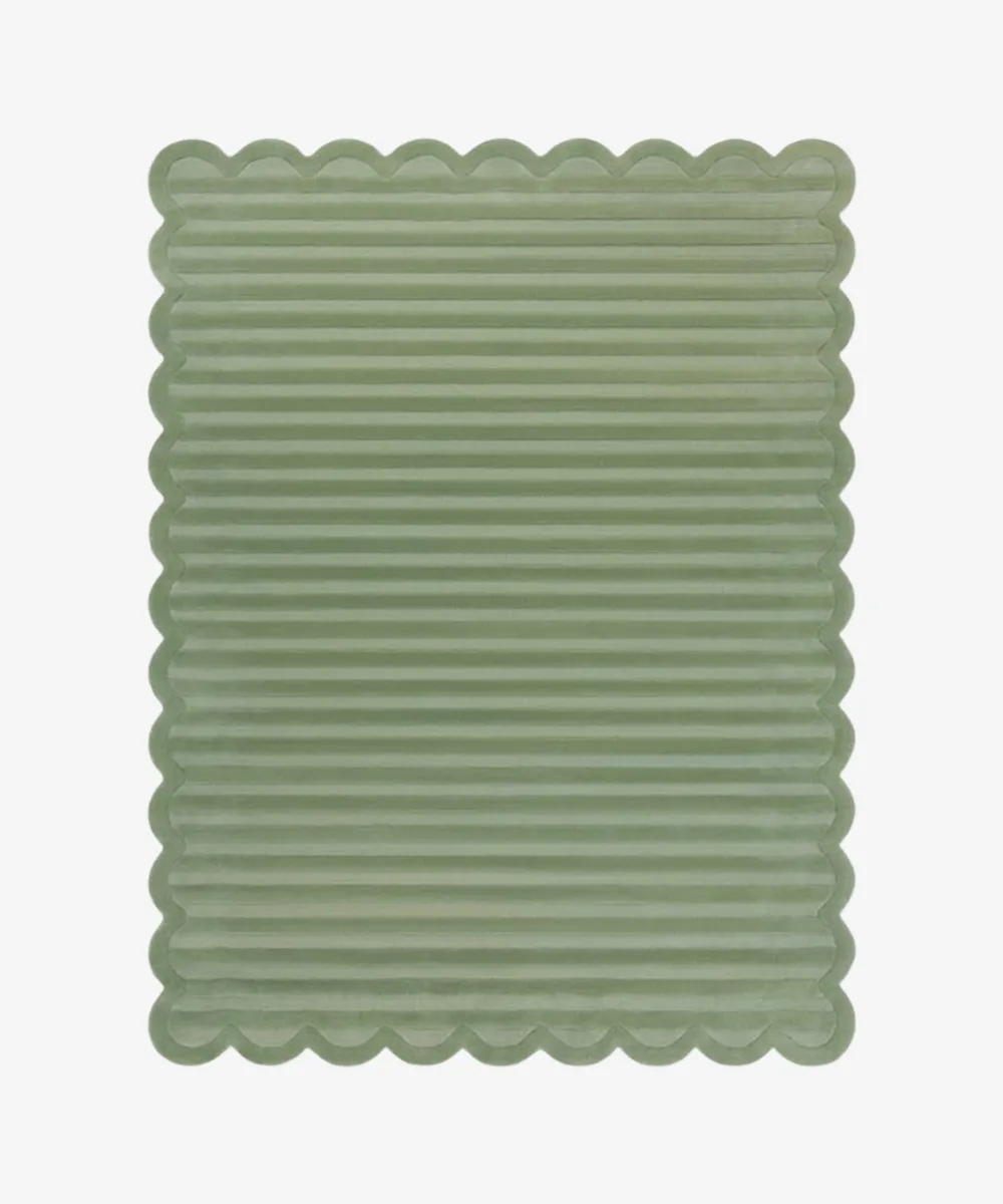 Top down view of a rug from the ScallopedRugs Green Rugs collection featuring a calming sage green color with a carved horizontal ribbed texture and signature scalloped edges.