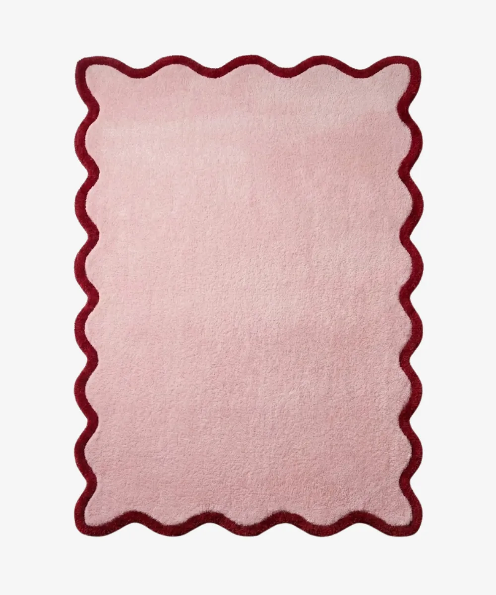 Top down view of a rectangular rug from the ScallopedRugs Pink Rugs collection featuring a soft blush pink wool center framed by a contrasting deep red burgundy scalloped edge.