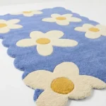 Low angle perspective of the Sea Tonic area rug highlighting the dense plush wool pile and the playful scalloped edge design perfect for a bright room.