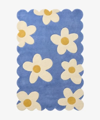 Top down view of the Sea Tonic rug featuring a fresh blue background with large white daisy motifs and yellow centers.