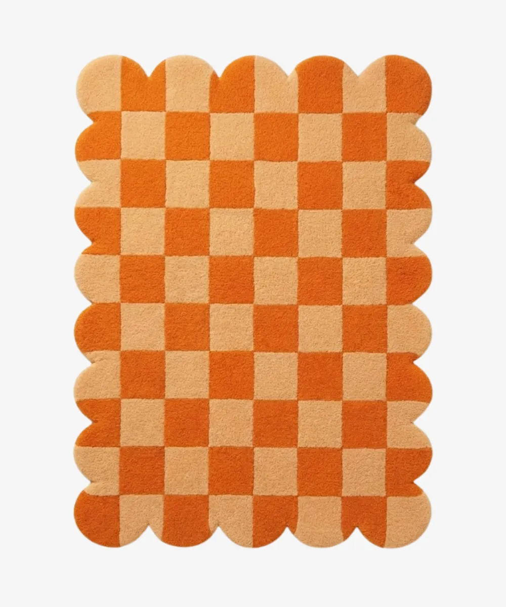 An orange and cream checkerboard rug with scalloped borders, linking to the Checkered and Grid pattern category.