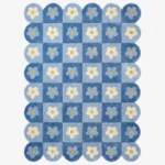 Top down view of the Sky Carousel rug featuring a playful checkerboard pattern in dark and light blue with white daisy flowers in every square.
