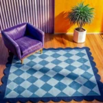 The Slate Haven rug styled in a vibrant modern living space with a purple velvet armchair and yellow walls, showing how the blue tones balance bold interior colors.