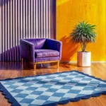 Low angle perspective view of the Slate Haven rug on a wooden floor, highlighting the plush hand-tufted wool texture and the precise finish of the scalloped edges.