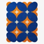 Top down flat lay of the Solar Indigo rug featuring a bold geometric pattern with deep blue ovals and vibrant orange diamond shapes on a cream background.