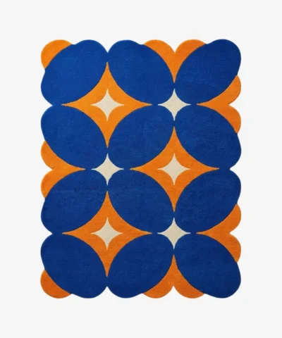 Top down flat lay of the Solar Indigo rug featuring a bold geometric pattern with deep blue ovals and vibrant orange diamond shapes on a cream background.