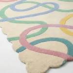 Angled perspective shot of the Sorbet Stream hand tufted rug highlighting the dense wool texture and the flowing multicolor doodle pattern.