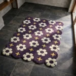 Perspective view of the Starlit Bloom rug placed on a dark tiled floor, featuring a deep purple background adorned with a repeating retro pattern of white flowers and yellow four-point stars, finished with a petal-contoured scalloped edge.