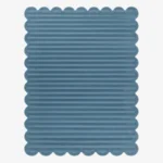 Top down view of the Still Tides rug featuring a solid dusty blue color with horizontal carved textures and decorative scalloped edges.