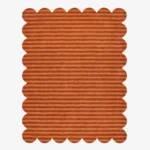 Top down view of the Sun Baked rug featuring warm rust and orange horizontal stripes with a carved texture and scalloped borders.