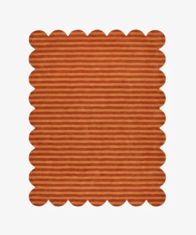 Top down view of the Sun Baked rug featuring warm rust and orange horizontal stripes with a carved texture and scalloped borders.