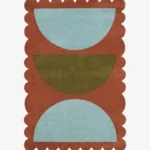 Top down view of the Sunbaked Form rug featuring a bold geometric pattern with large light blue and olive green semi-circles on a terracotta rust wool background with scalloped edges.