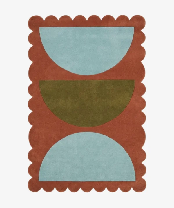 Top down view of the Sunbaked Form rug featuring a bold geometric pattern with large light blue and olive green semi-circles on a terracotta rust wool background with scalloped edges.