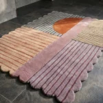 Close-up detail of the Terra Rift rug, highlighting the carved ridge texture of the stripes and the soft pastel color palette against the terracotta accents.