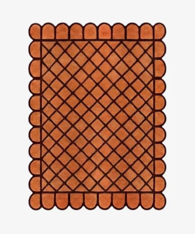 Top down view of the Terracotta Grid rug featuring a warm orange wool background with a bold dark brown square grid pattern and custom scalloped edges.