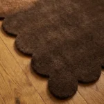 Close-up angled view of the walnut runner rug, highlighting the dense, plush hand-tufted New Zealand wool and viscose silk texture and the gracefully contoured brown scalloped border.