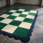 Perspective view of the Arcet Offset rug placed on a dark tiled floor, highlighting the plush hand-tufted wool texture and the timeless green and white check design.