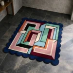 High angle view of the Arched Junction Square rug featuring an interlocking geometric maze pattern in pink, green, and burgundy, framed by a dark blue scalloped border.