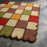 Close-up low angle view of the Autumn Tile Square rug, showcasing the plush hand-tufted wool texture, the distinct colorful square blocks, and the carved dark brown scalloped border.