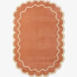 Top down view of the Cedar Patio rug featuring a warm rust terracotta background with a decorative cream wavy contour line and scalloped edges.