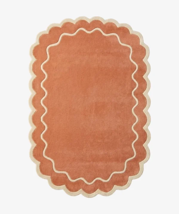 Top down view of the Cedar Patio rug featuring a warm rust terracotta background with a decorative cream wavy contour line and scalloped edges.