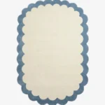 Top down view of the Cloud Marina rug featuring a soft cream center framed by a calming light blue scalloped border.