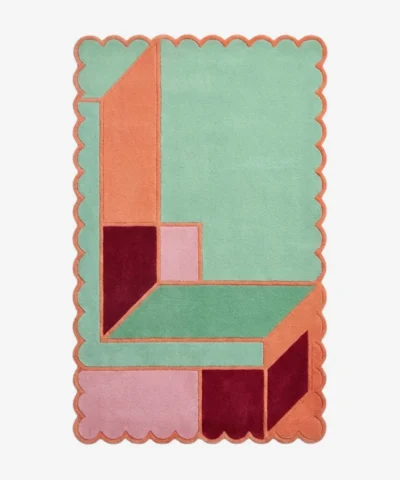 Top down view of the Coral Courtyard rug featuring an architectural geometric pattern with L-shaped blocks in fresh mint green and vibrant coral orange, finished with custom scalloped edges.