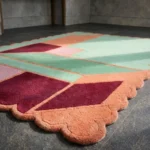 Low angle close-up of the Coral Courtyard rug, highlighting the plush hand-tufted wool pile and the precise carving between the mint green and coral border sections.