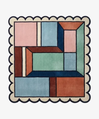 Top down view of the Dusty Dune Square rug featuring a geometric color block design in dusty blue, terracotta, and mint green, framed by a dark blue scalloped border.