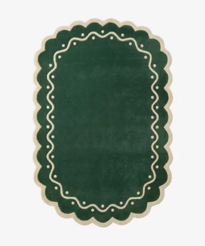 Top down view of the Emerald Veranda rug featuring a solid emerald green background with a decorative cream border containing wavy lines and polka dots.
