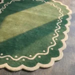 Close-up detail of the Emerald Veranda rug's corner, showcasing the plush wool pile and the intricate cream wavy line and dot accents.