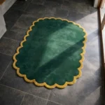 High angle perspective of the Forest Royale rug placed on a dark tiled floor, highlighting the rich green tones and soft hand-tufted wool texture.