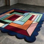Perspective view of the Framed Passage rug showing the 3D effect of the colorful maze pattern and the plush hand-tufted wool texture on a tiled floor.