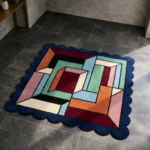 High angle view of the Framed Passage Square rug featuring a bold interlocking geometric design in teal, pink, and burgundy, framed by a dark blue scalloped border.