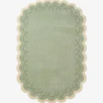 Top down view of the Garden Lace rug featuring a soft sage green center framed by a cream scalloped border with a delicate leafy vine pattern.
