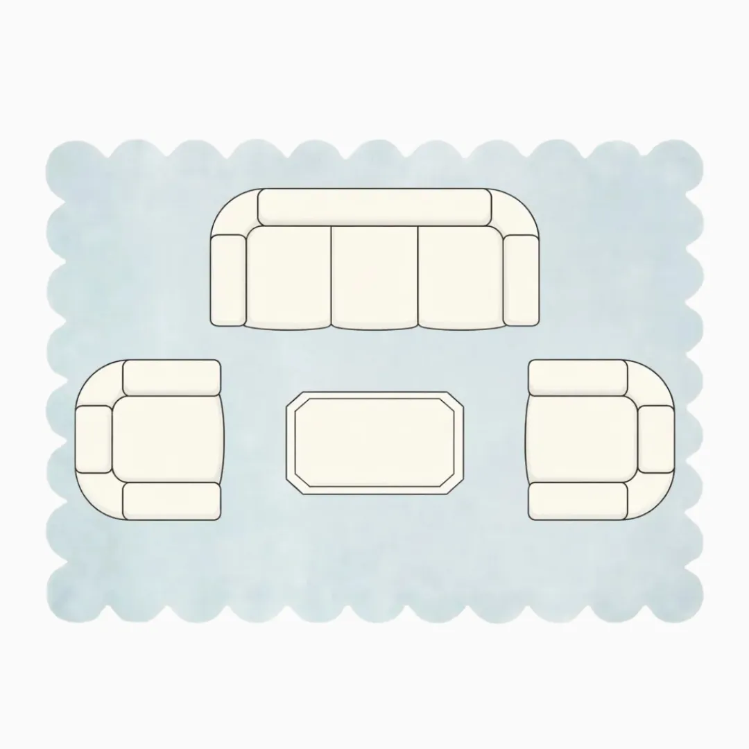 Top down diagram of a large living room layout featuring a 9x12 or larger scalloped rug, showing a sofa and two armchairs with all legs placed fully on the rug to create a unified zone.