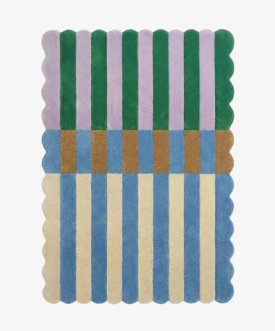 Top-down view of the Mint Gelato rug against a white background, featuring a vibrant color-block striped pattern with vertical bands of purple and dark green on the top half, a transitional band of brown and blue blocks in the center, and alternating cream and light blue stripes on the bottom half, all framed by a continuous scalloped border.