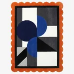 Top view of the Noctra Apex hand tufted wool rug featuring a playful orange scalloped border surrounding a modern geometric composition of navy blue circles and charcoal grey blocks on a cream background.