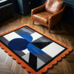 Top down view of the Noctra Apex rug featuring a bold geometric composition with deep blue semi-circles, grey triangles, and black and white accents, finished with a vibrant orange scalloped border.