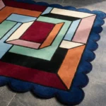 Perspective view of the Offset Vault rug showing the depth of the 3D-style geometric pattern and the plush hand-tufted wool texture on a tiled floor.
