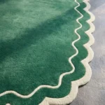 Close-up detail of the Pine Estate rug, showcasing the plush hand-tufted wool pile and the contrasting cream wavy border and scalloped edge.