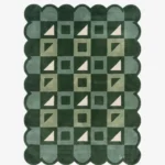 Top-down view of the Pine Patchwork rug against a white background, featuring a repeating geometric patchwork pattern of squares and triangles in shades of dark green, soft green, and cream, framed by a continuous dark green scalloped border.